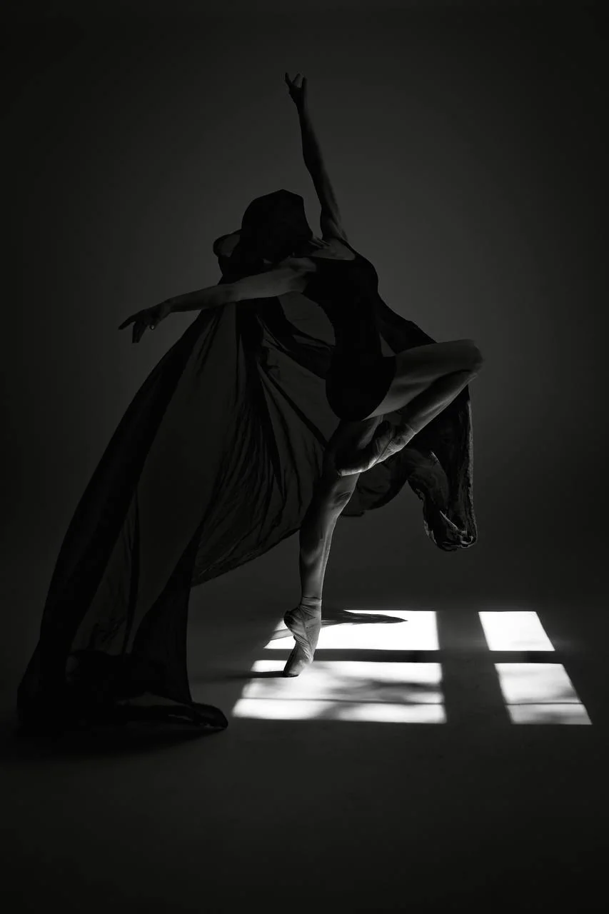 Full-length black-and-white portrait of Zuzanna Kidziak dancing en pointe with flowing fabric