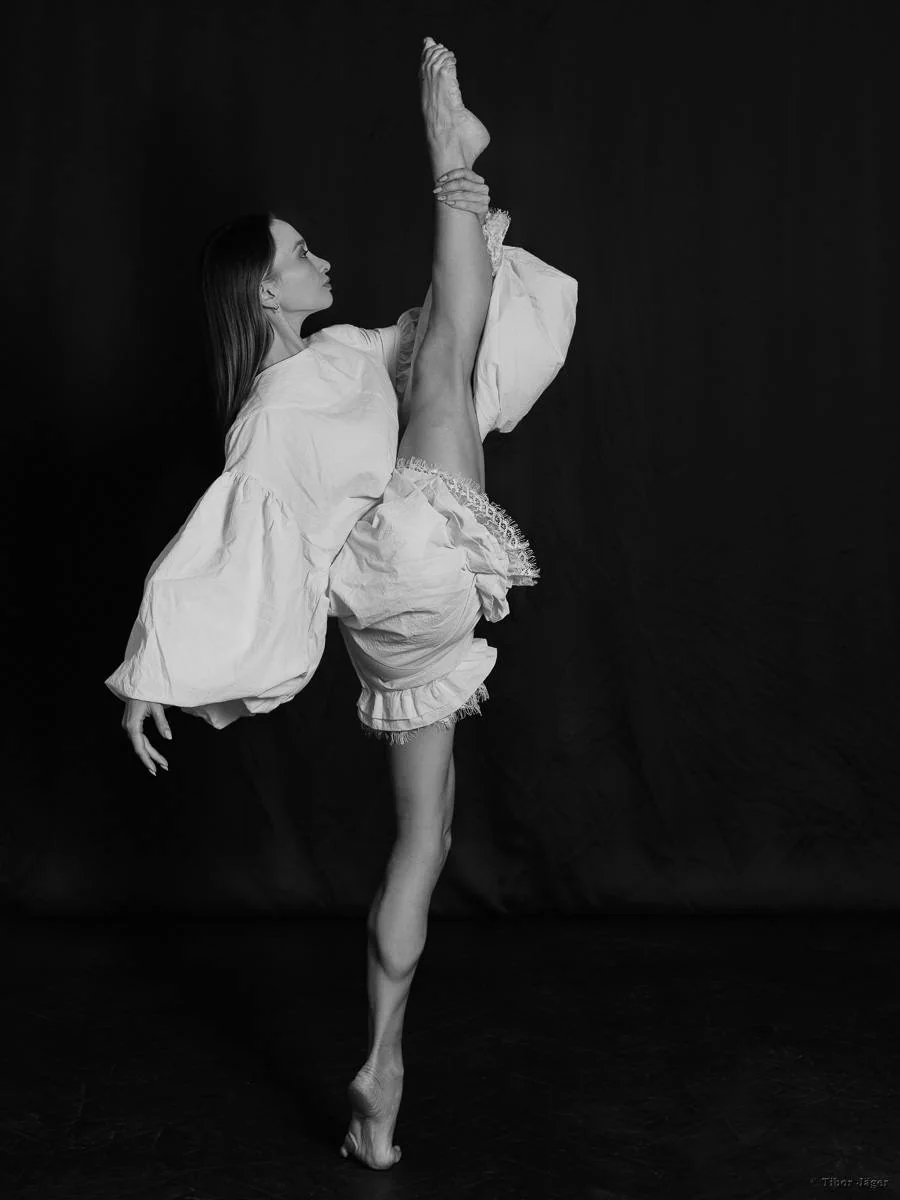 Zuzanna Kidziak creating a sculptural ballet line in a black-and-white portrait